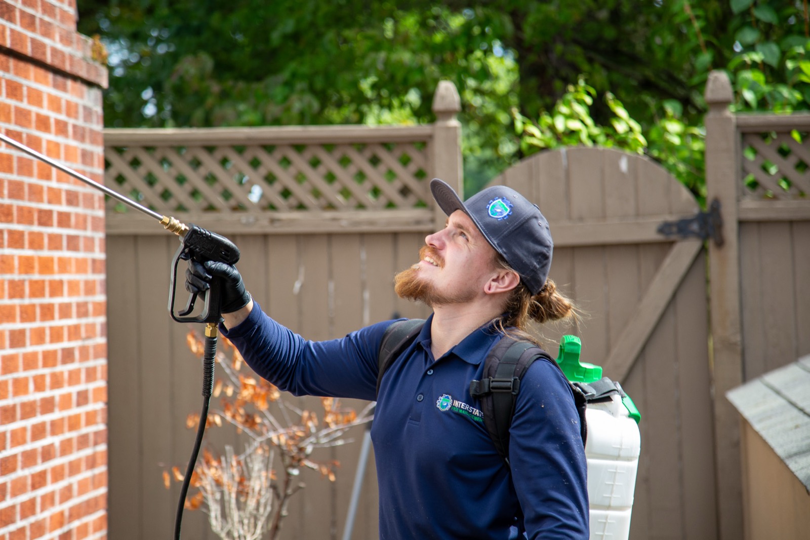 Interstate Pest Management technician treating a home exterior in Olympia